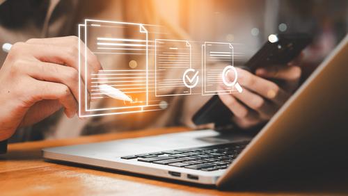 Hand arbeitet hinter Scheibe am Laptop 