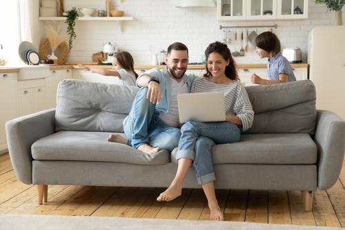 Paar sitzt auf Sofa und hat ein Papier in der Hand 