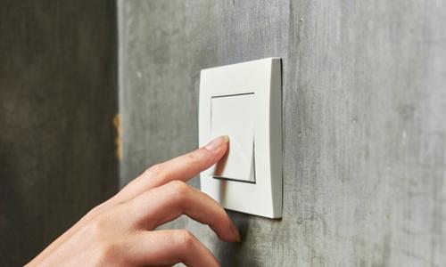Finger tippt auf Lichtschalter.